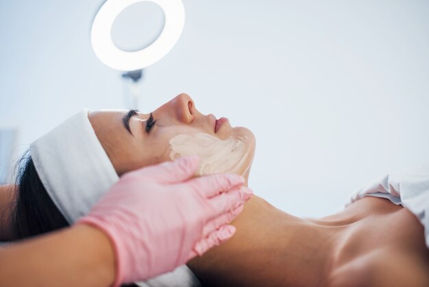 Close up view of woman that lying down in spa salon and have face cleaning procedure by the mask.