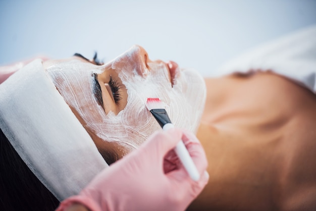 Close up view of woman that lying down in spa salon and have face cleaning procedure by the mask.