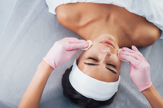 Close up view of woman that lying down in spa salon and have face cleaning procedure.