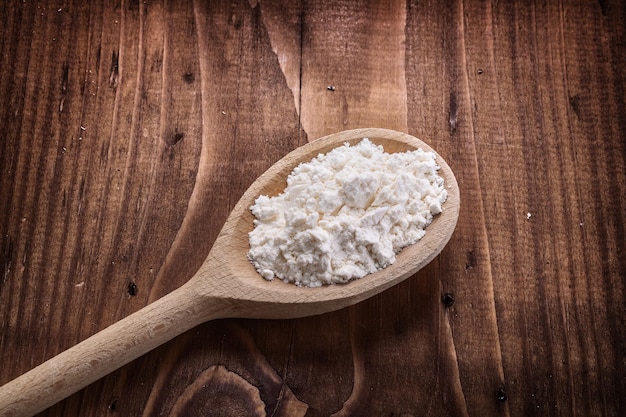 Close up view wooden spoon with flour on vintage board