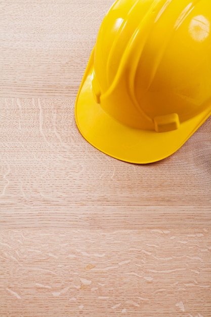 close up view yellow helmet on wooden board construction concept