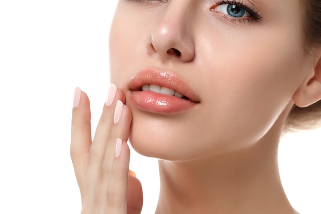 Close up view of young beautiful caucasian woman touching her lips isolated over white background