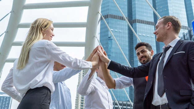 Close up view of young business people putting their hands together. Unity and teamwork co