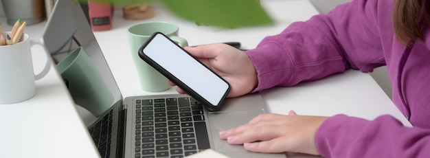 Close-up view of young collage girl using her smartphone