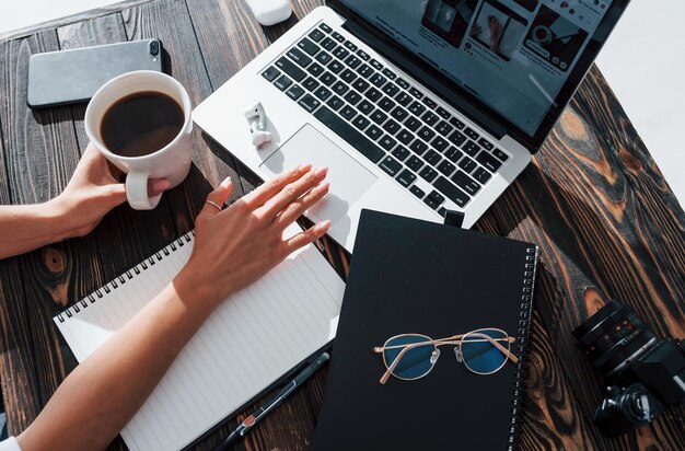 Close up view of young female freelancer that working indoors in the office at daytime