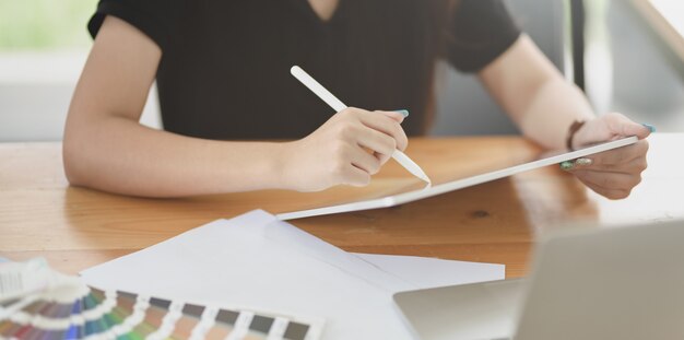 Vista del primo piano di giovane grafico femminile che lavora al suo progetto