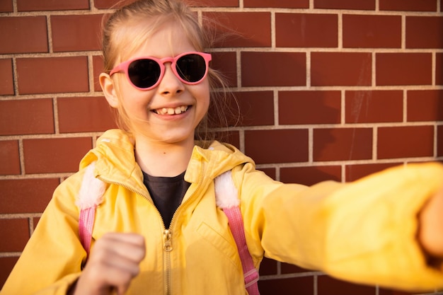 Close up view of young girl in sunglasses smiling at camera