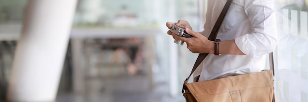 Close up view of young male photographer checking picture on digital camera