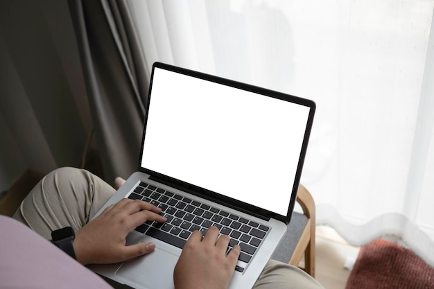 Close up view young woman sitting on couch and using laptop computer at home