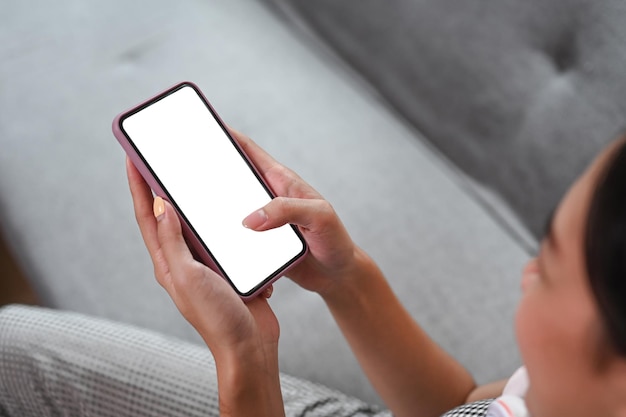 Close up view young woman using smart phone while sitting sofa