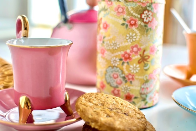 Close-up of vintage colorful cup of tea with cookies and teapot breakfast and morning concept