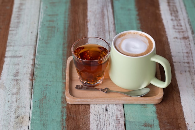 Photo close up a vintage cup of hot latte coffee on wooden vintage desk, coffee with milk