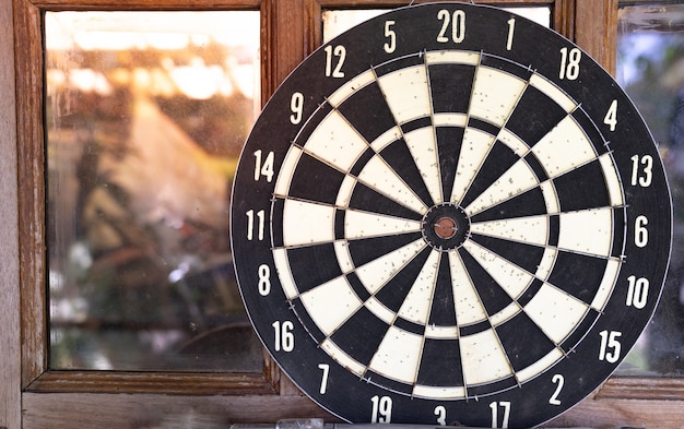 Close up vintage dart board against wooden window 