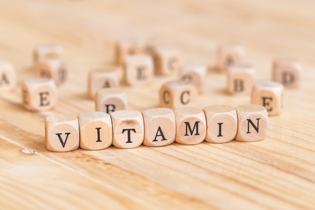 Close up vitamin word made from wooden letters on the table 