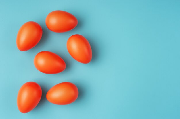 Close up of vivid orange Easter eggs on blue-green background