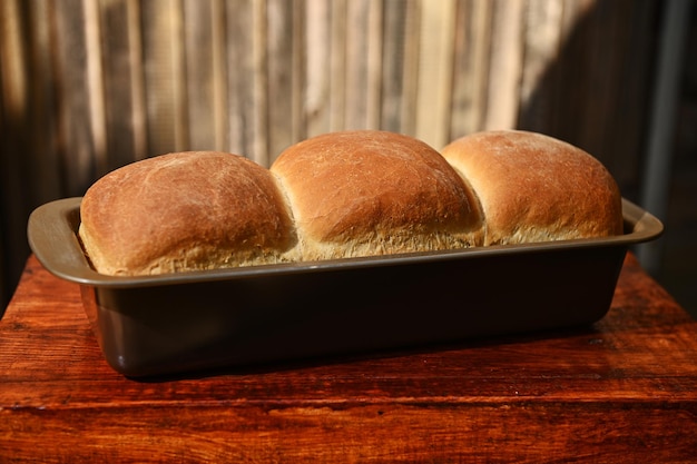 Close-up voedselsamenstelling van een vers gebakken warm volkoren brood op een houten achtergrond met kopieeradvertentieruimte