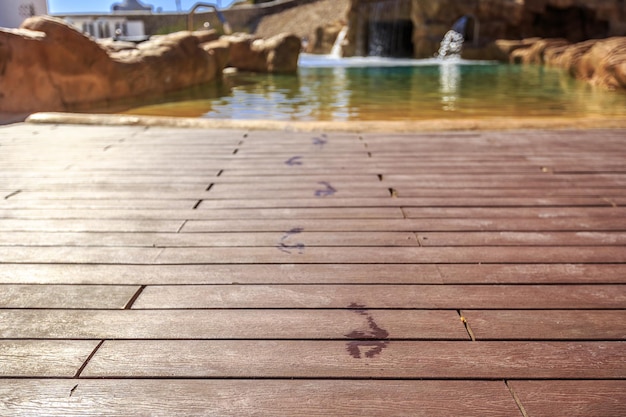 Close-up voetafdrukken op de houten vloer achter het zwembad