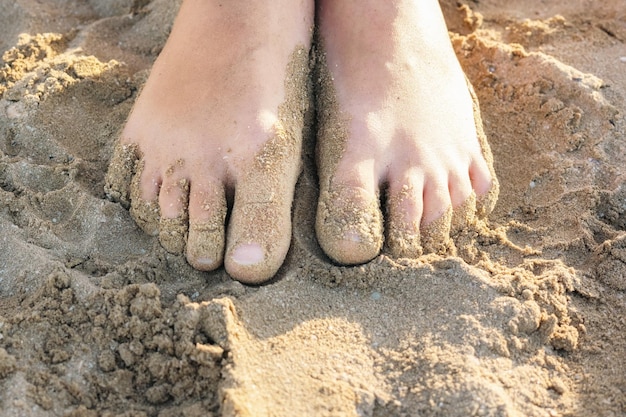 Close-up voeten van kind in het zand op een zandstrand Bovenaanzicht plat lag Vakantie concept