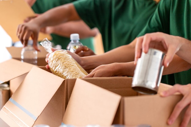 close up of volunteers packing food in boxes