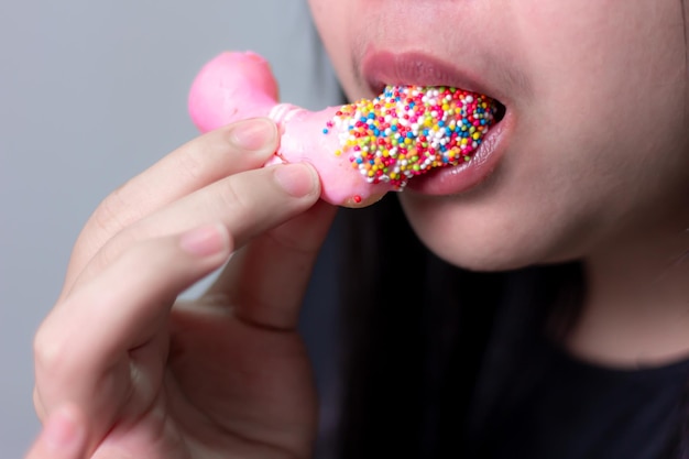 Close-up Vrouw die aardbeien donut eet onduidelijke achtergrond