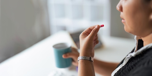 Close-up vrouw die pil in de hand houdt met water zich ziek voelt vrouw gaat pijnstiller nemen van hoofdpijn pijnstiller gezondheidszorg medicijn behandeling therapie patiënt ziekte ziekte concept