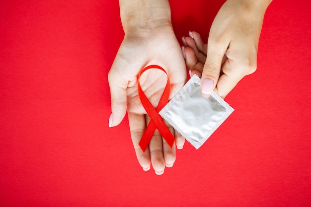 Close Up vrouw hand met rood lint HIV, Wereld Aidsdag bewustzijn lint.