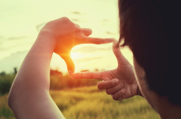 close-up vrouw maken hand verwoording gebaar ver met zonsondergang