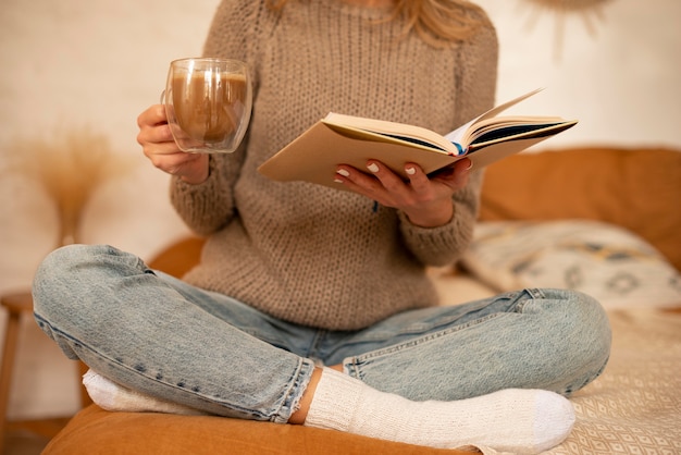 Foto close-up vrouw met boek en drankje