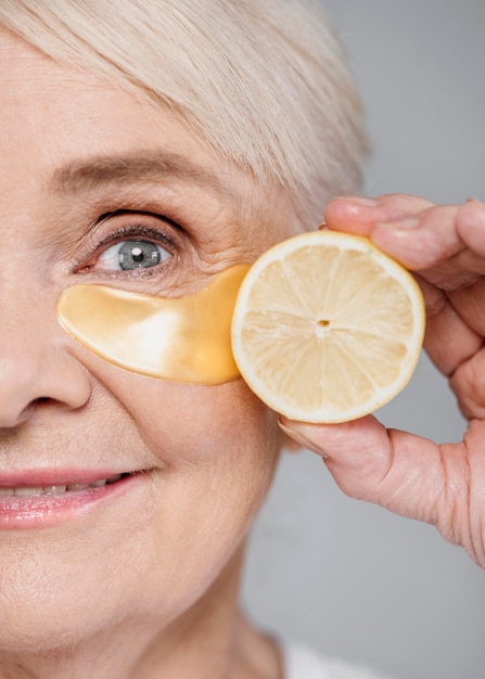Close-up vrouw met oog patch en schijfje citroen
