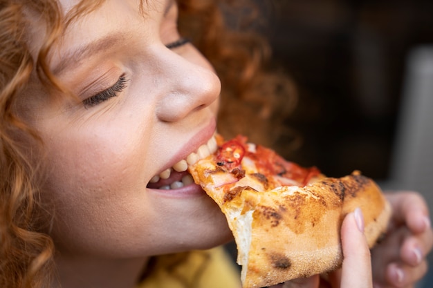 Foto close-up vrouw pizza eten