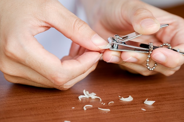 Close-up vrouw vingernagels worden bijgesneden met nagelknipper. Het concept van zorg, schone vingernagels.