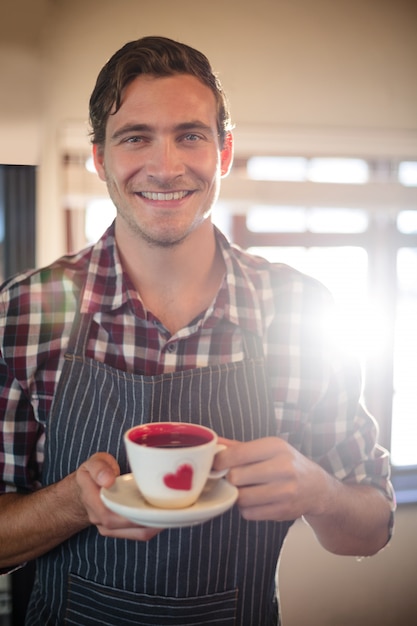 Photo close-up of waiter holding a coffee cup at counter