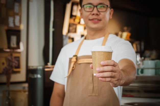 Close-up of a waitress serving a cup of coffee. Selective focus.