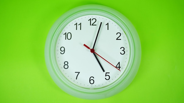 Close-up of wall clock on green background