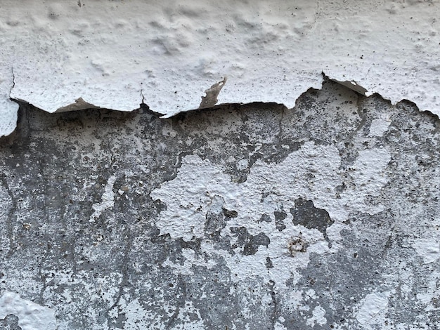 A close up of a wall with a white paint that has been peeling off.