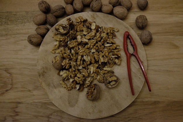 Photo close-up of walnuts and nutcracker on table