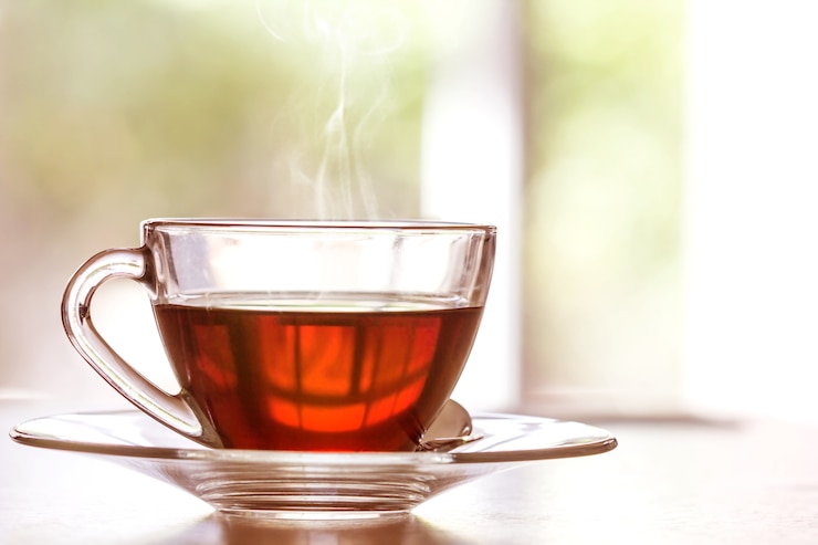 Photo close up warm black tea cup on the wooden table in living room , relax with tea time concept