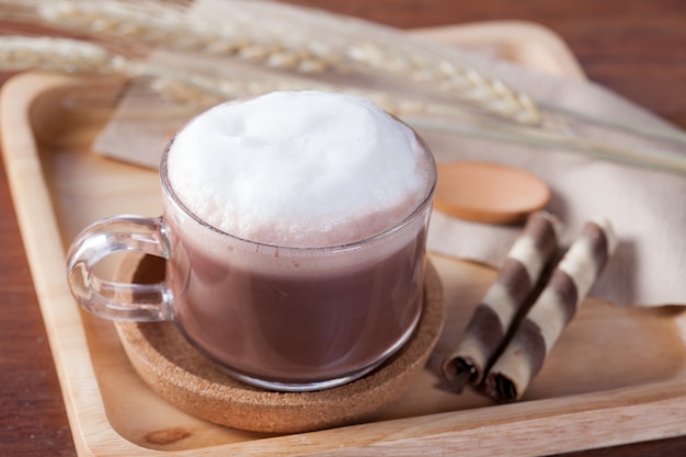 close-up warme chocolademelk met snack op houten bord op houten tafel voor ontbijt.