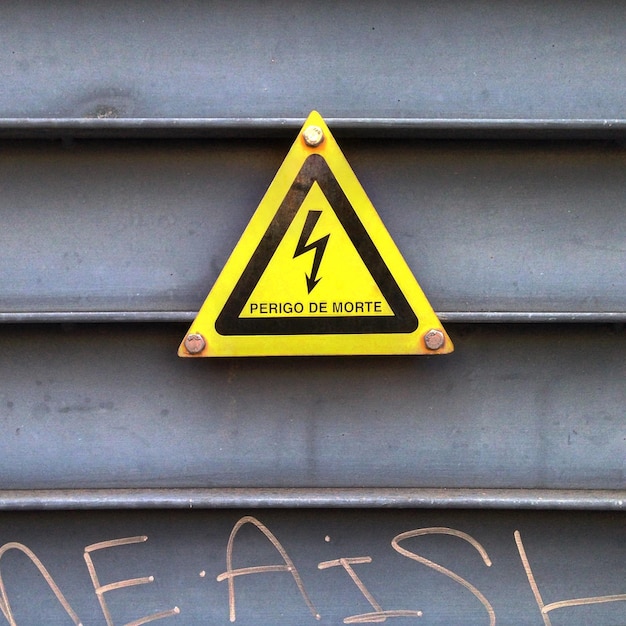 Photo close-up of warning sign mounted on metallic structure