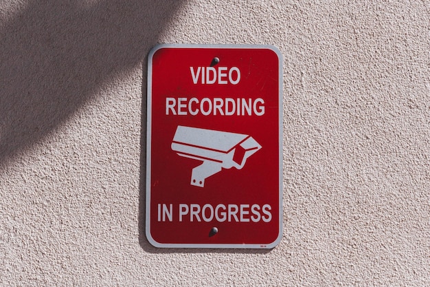 Close-up of warning sign on wall of video recording and surveillance