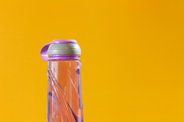 Close-up of water bottle against yellow background