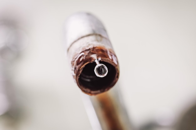 Close up of water dripping from old rusted tap Problems with water supply concept toned photo