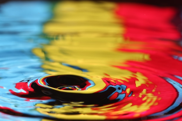 close up of a water drop falling and impact with a body of water