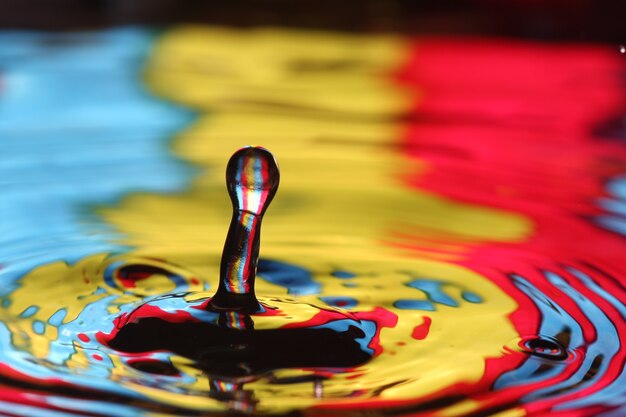 Foto primo piano di una goccia d'acqua che cade e impatta con un corpo d'acqua