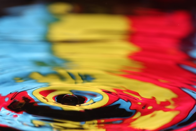 Photo close up of a water drop falling and impact with a body of water