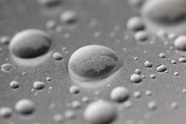 Photo close-up of water drops on metal surface