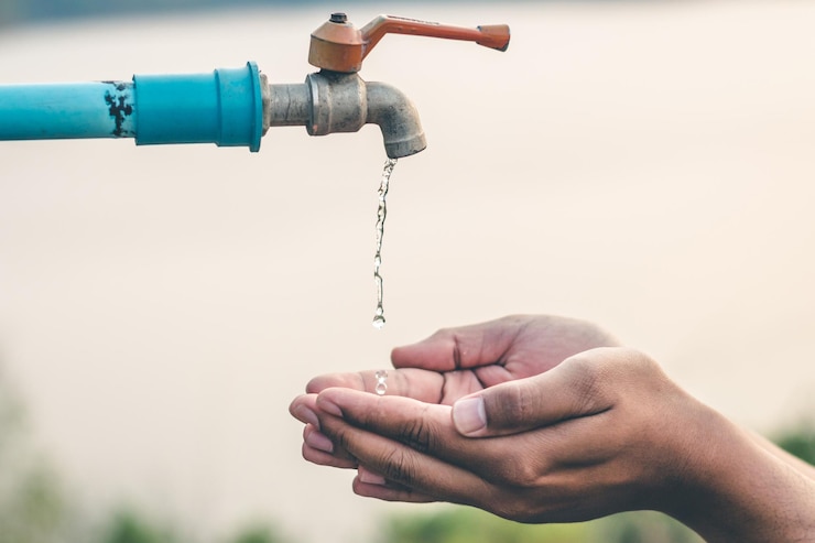 Photo close-up of water falling on cropped hands