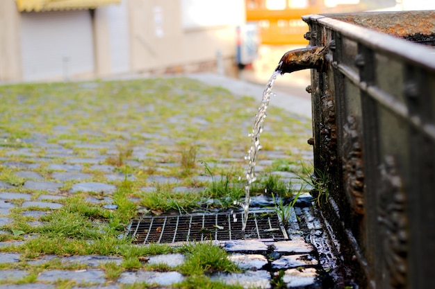 Photo close-up of water falling on rusty metal