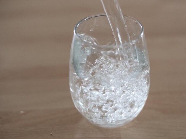 Foto close-up di un bicchiere d'acqua sul tavolo