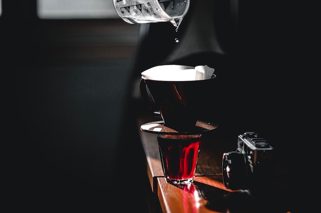 Close-up of water pouring in coffee maker on wooden table